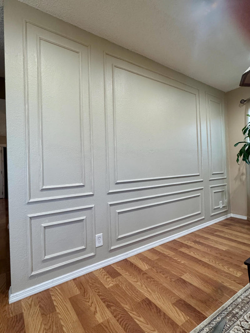 DIY wall molding kit installed in real home showing decorative wall panel result-Wall with decorative paneling in a room with wooden flooring