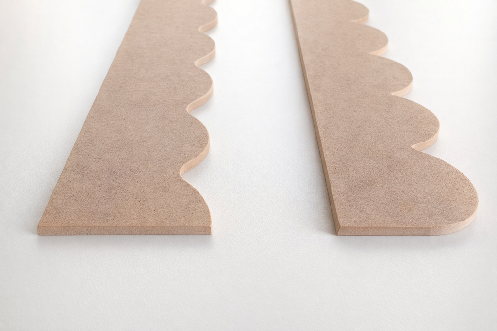 Raw MDF scallop and curve wall molding panels close-up detail on a white background