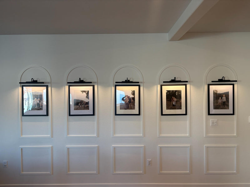 real home accent wall created with DIY arched MDF wall molding trim kit- Five framed pictures on a wall with arch-shaped frames.