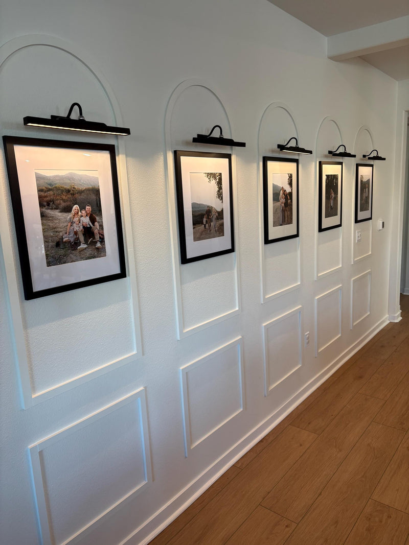 real home accent wall created with DIY arched MDF wall molding trim kit-Row of framed photographs on a wall with paneling