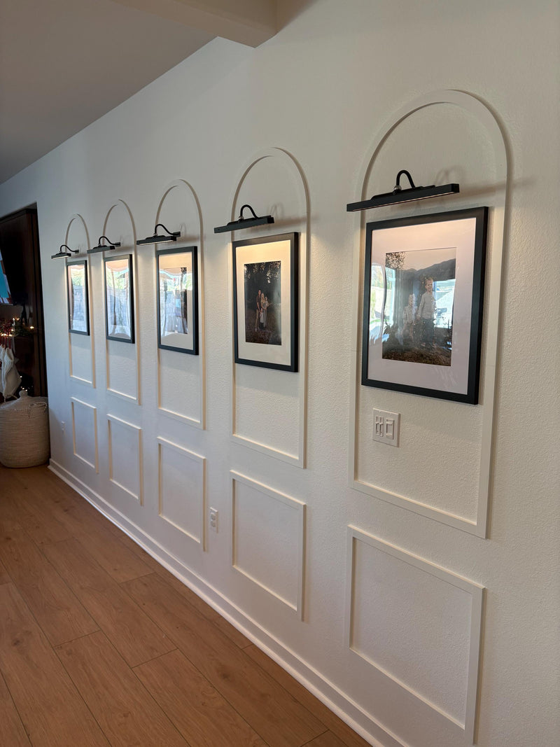 real home accent wall created with DIY arched MDF wall molding trim kit-Wall with framed pictures and arch-shaped picture hangers