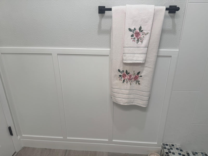 customer installed shaker-board and batten wall molding kit showing finished panel wall design-Two embroidered towels hanging on a towel rack against a tiled wall.