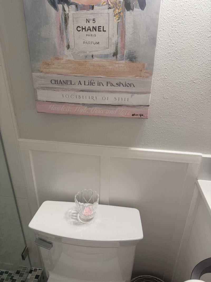 customer installed shaker-board and batten wall molding kit showing finished panel wall design-Poster of Chanel books on a wall above a toilet with a glass on top.