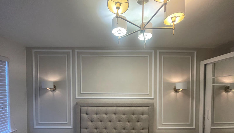 Modern chandelier hanging from a ceiling in a room with wall molding kits.