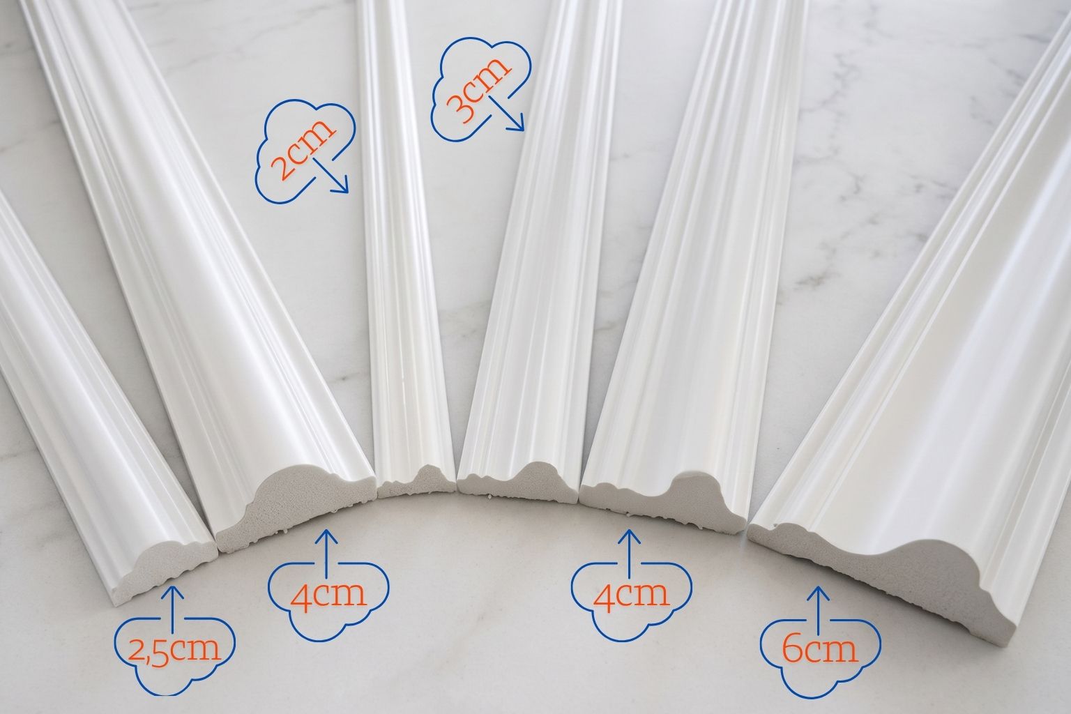 Six white decorative molding profiles arranged on a light marble surface, with blue cloud-shaped callouts showing different profile heights and widths such as 2cm, 3cm, 2.5cm, 4cm, 4cm, and 6cm.